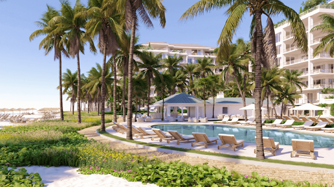 Palm trees and lounge chairs surround a large hotel pool.