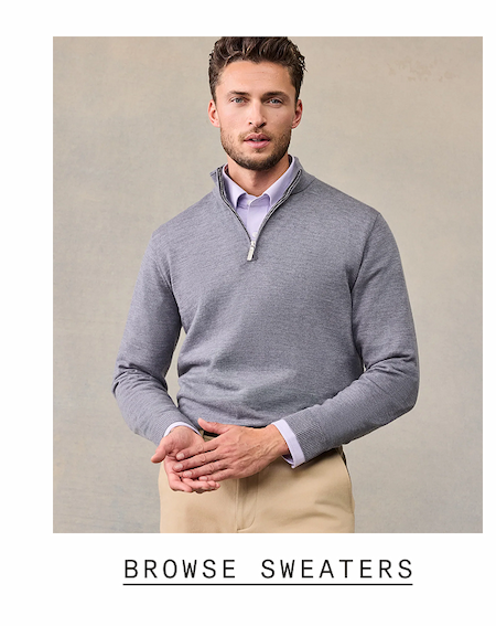 Man wearing a heather gray quarter-zip merino sweater layered over a light blue dress shirt, with khaki chinos visible at the waist. Text reads: "BROWSE SWEATERS"