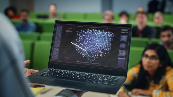 laptop showing dots and lines in advanced artificial neural network, with students in the background