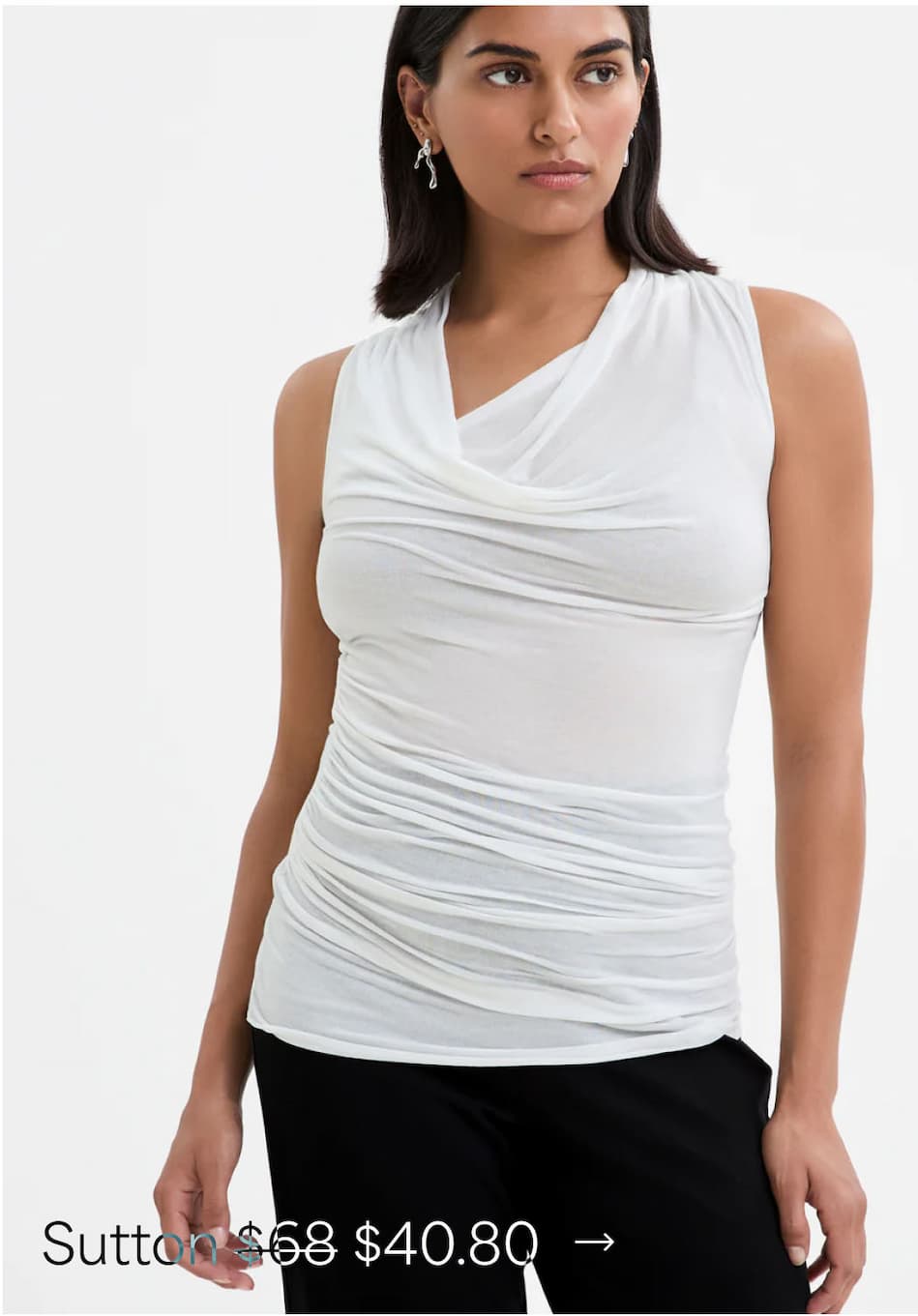 Sejal wears The Sutton Top with ruched sides and black trousers.