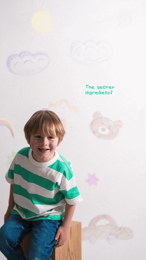 Child wearing a green and white striped t-shirt playing in a setting with illustrated clouds and a bear, with the text Children's Day with Petals Latte Bowls visible in the image