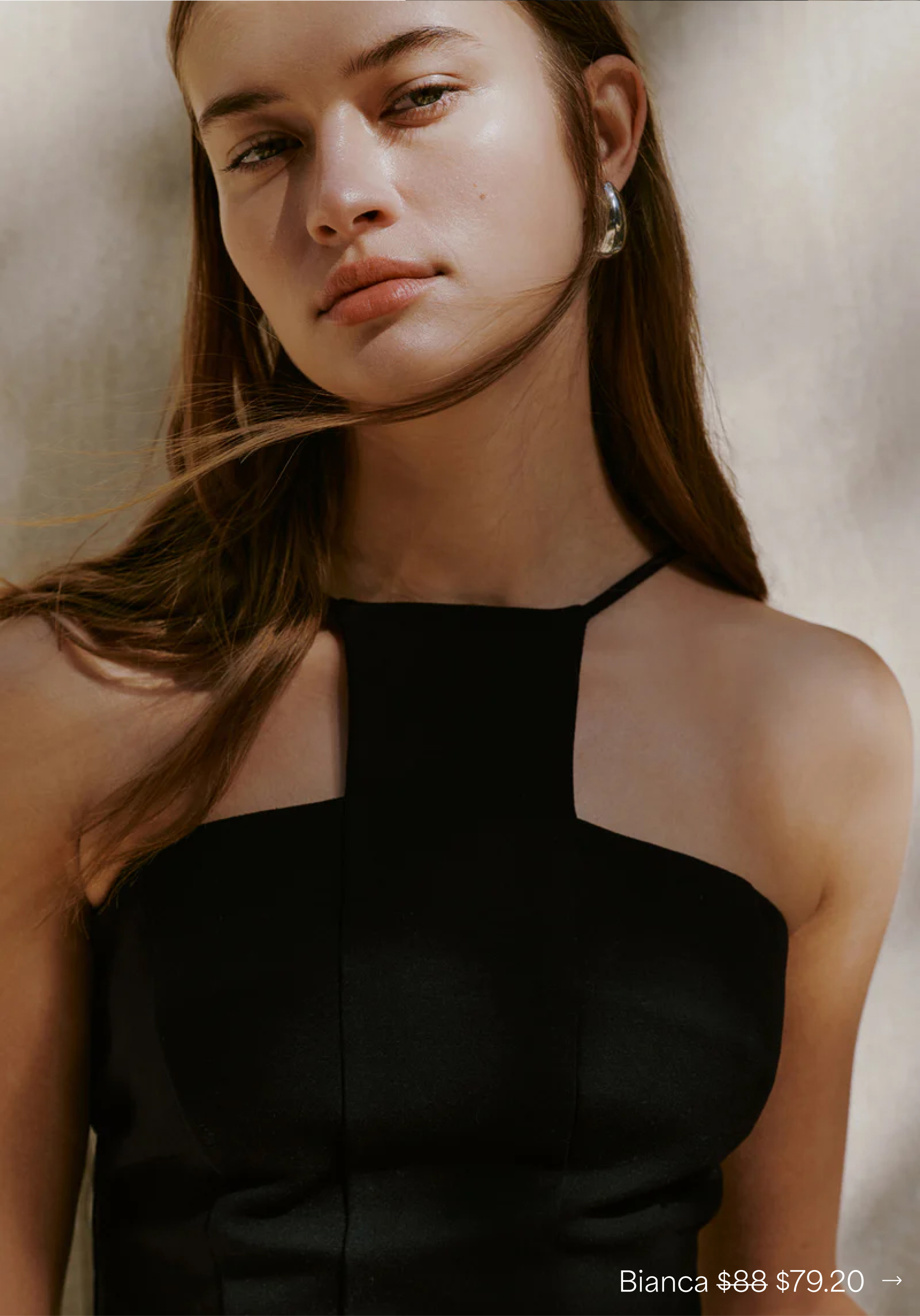 Close-up of Bianca wearing The Bianca Top with slim straps and windswept hair.