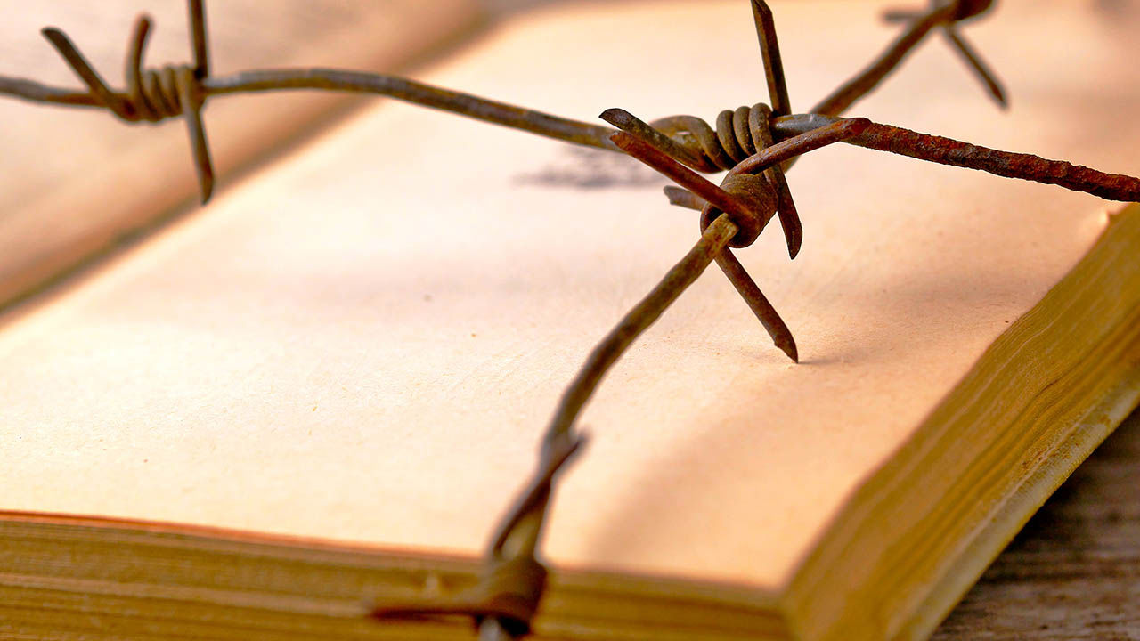 Rusty barbed wire around an old book