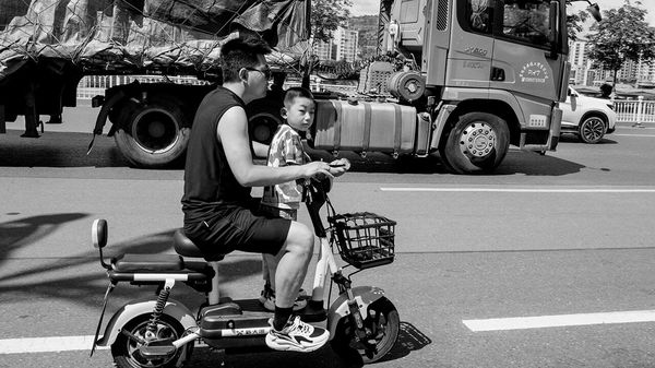 A father and his son ride an electric scooter, Tianshui, Gansu province, China,