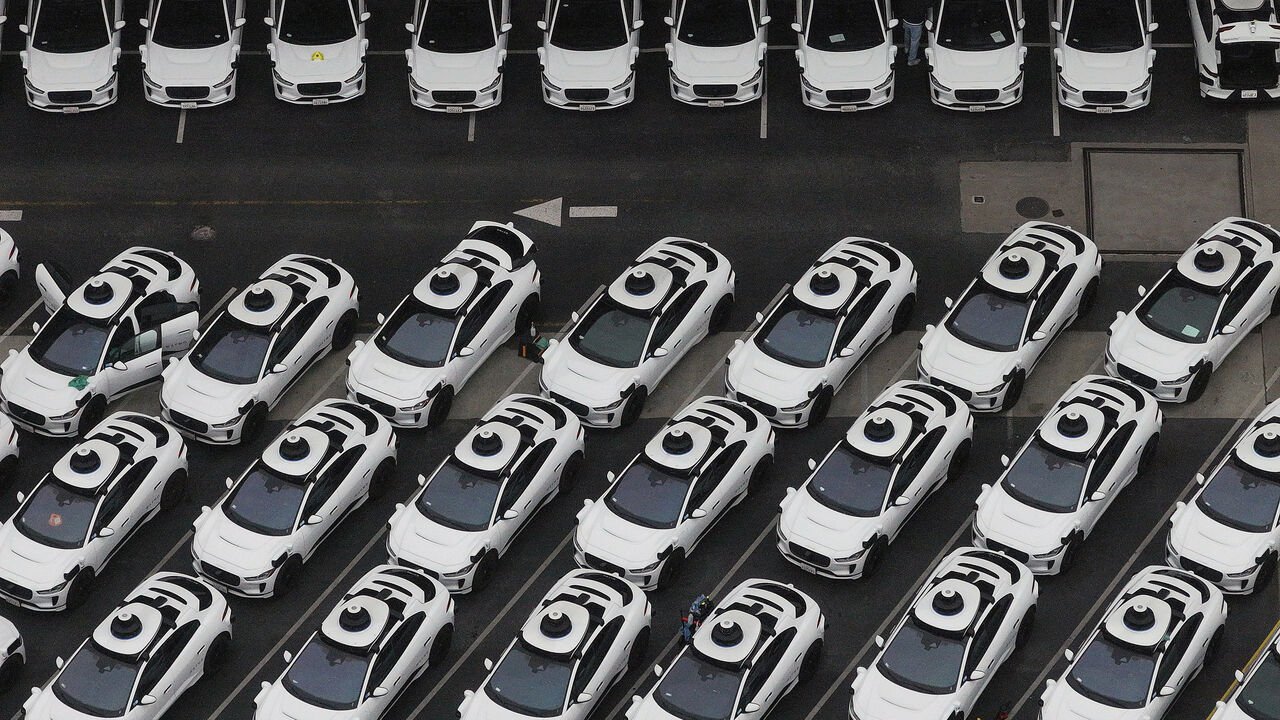 Waymo cars are seen parked at a Waymo facility.