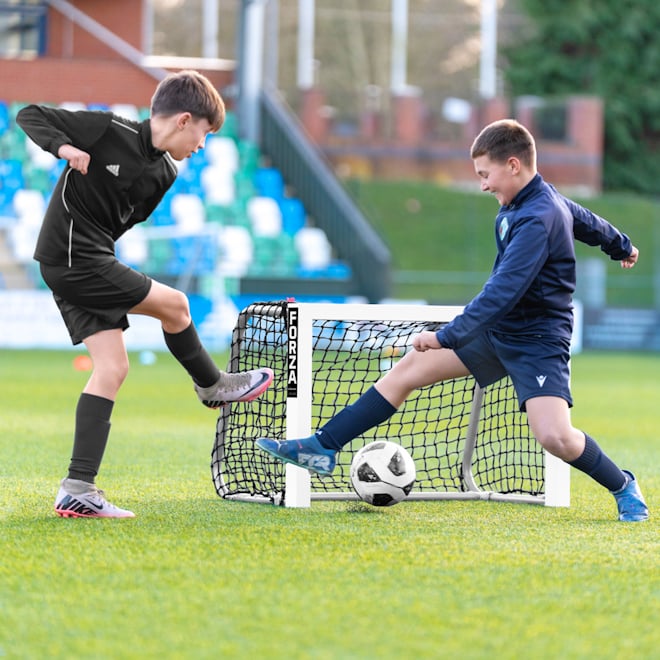 Two players battling it out in front of a FORZA ALU Mini Target Goal.