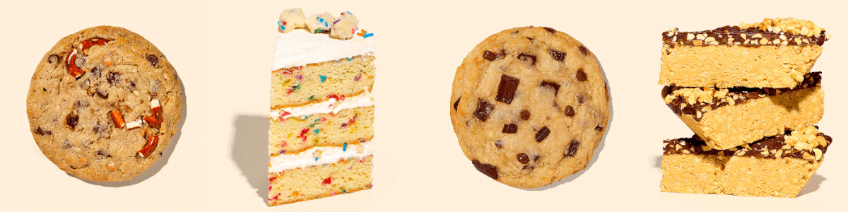 Animated marquee-style GIF of four Milk Bar desserts moving from right to left across a beige background: a stacked serving of Skippy Chocolate Peanut Butter Crunch Pie bars topped with glossy chocolate and chopped peanuts; a Chocolate Chip ’n Chunk Cookie with large chocolate pieces; a tall slice of Birthday Cake with rainbow sprinkles baked into the layers and white frosting; and a Compost Cookie with visible chocolate chips and pretzel pieces baked into the cookie.