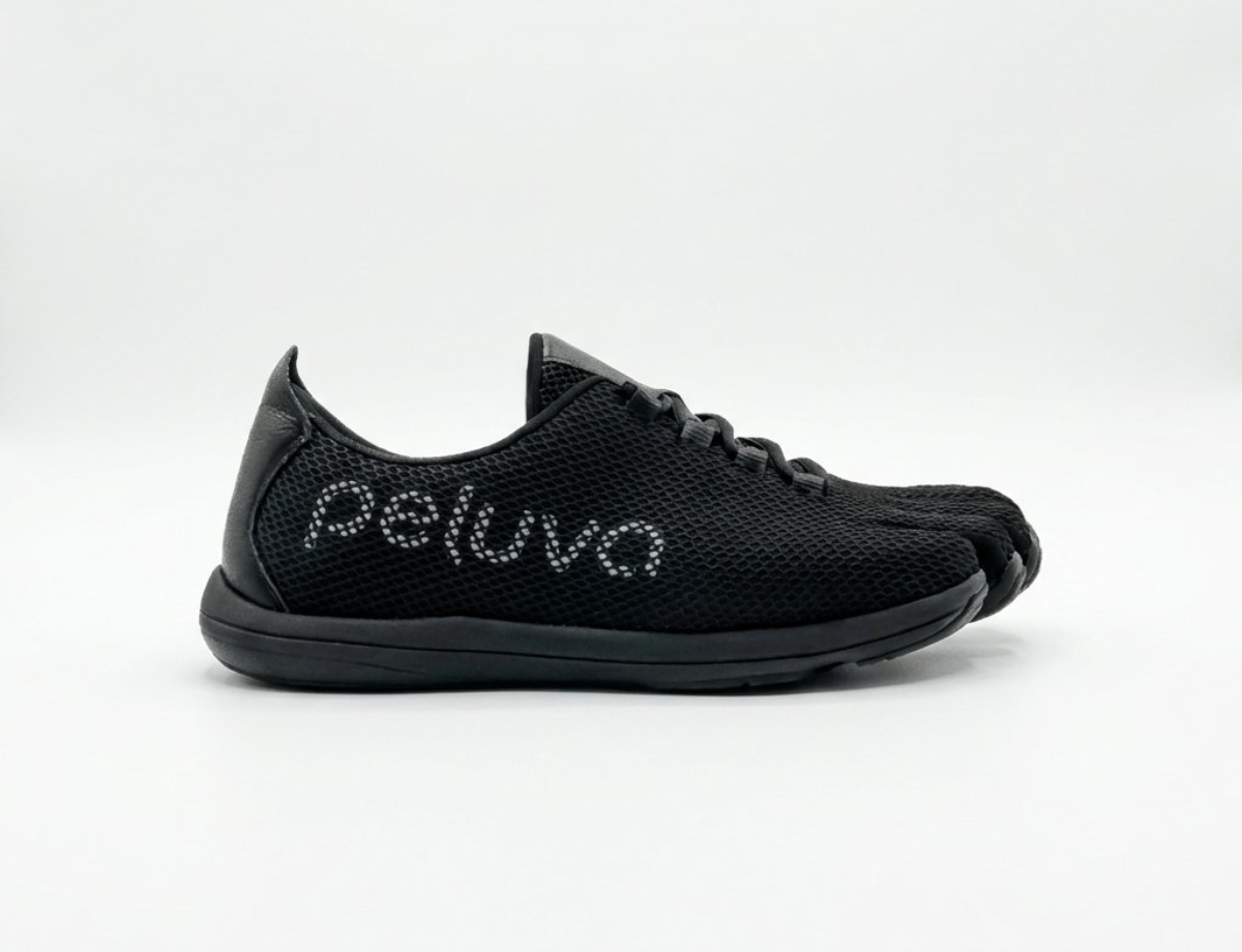 Side profile of a black Peluva minimalist training shoe with a toe-shaped front and "peluva" logo stitched across the side, shown against a plain light gray background.