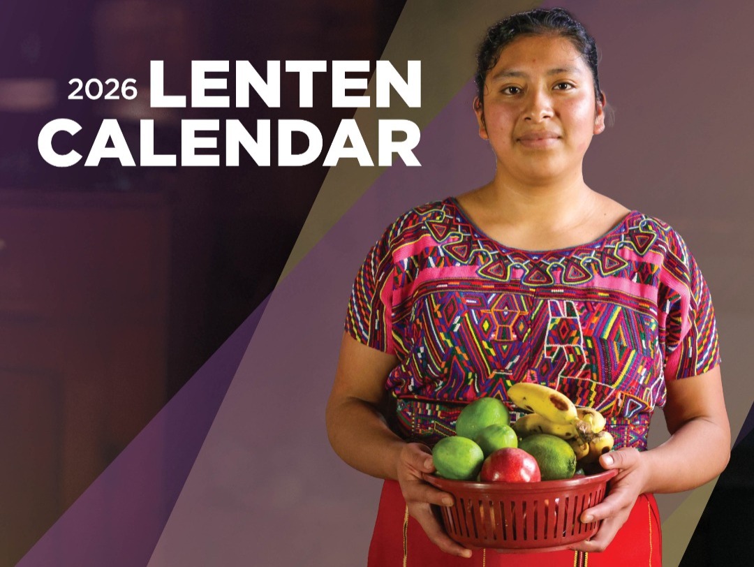 A woman holds a bowl of fruit.