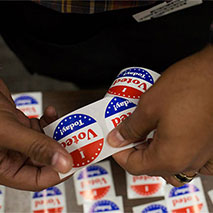 Hands peel off an "I Voted Today" sticker.
