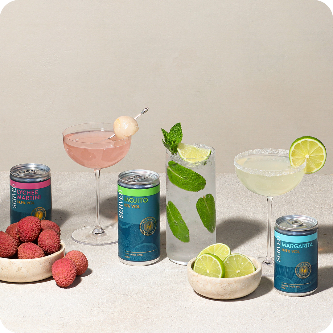 an image of a group of four cans of soda next to a lime