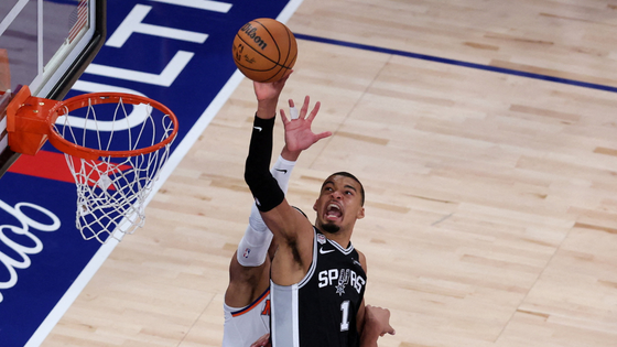 Basketball players shoot the ball.