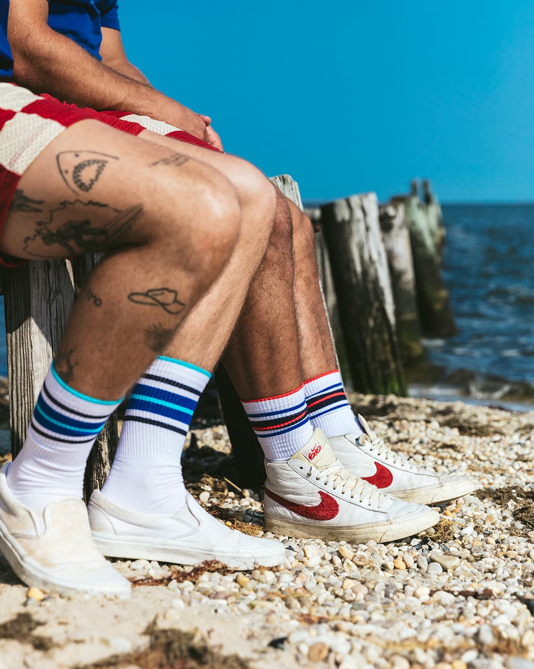 Three pair of white crew socks with various colored stripes at the top