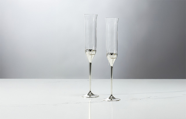 Two glass champagne flutes from the Vera Wang Love Knots collection, each with a silver stem.