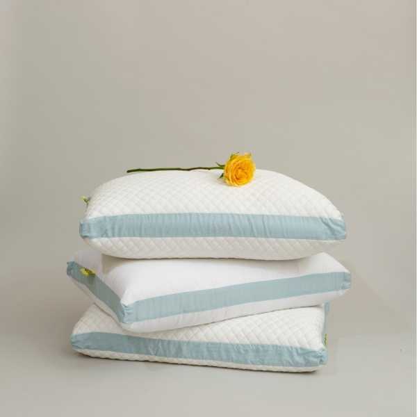 a stack of pillows with a yellow flower on top