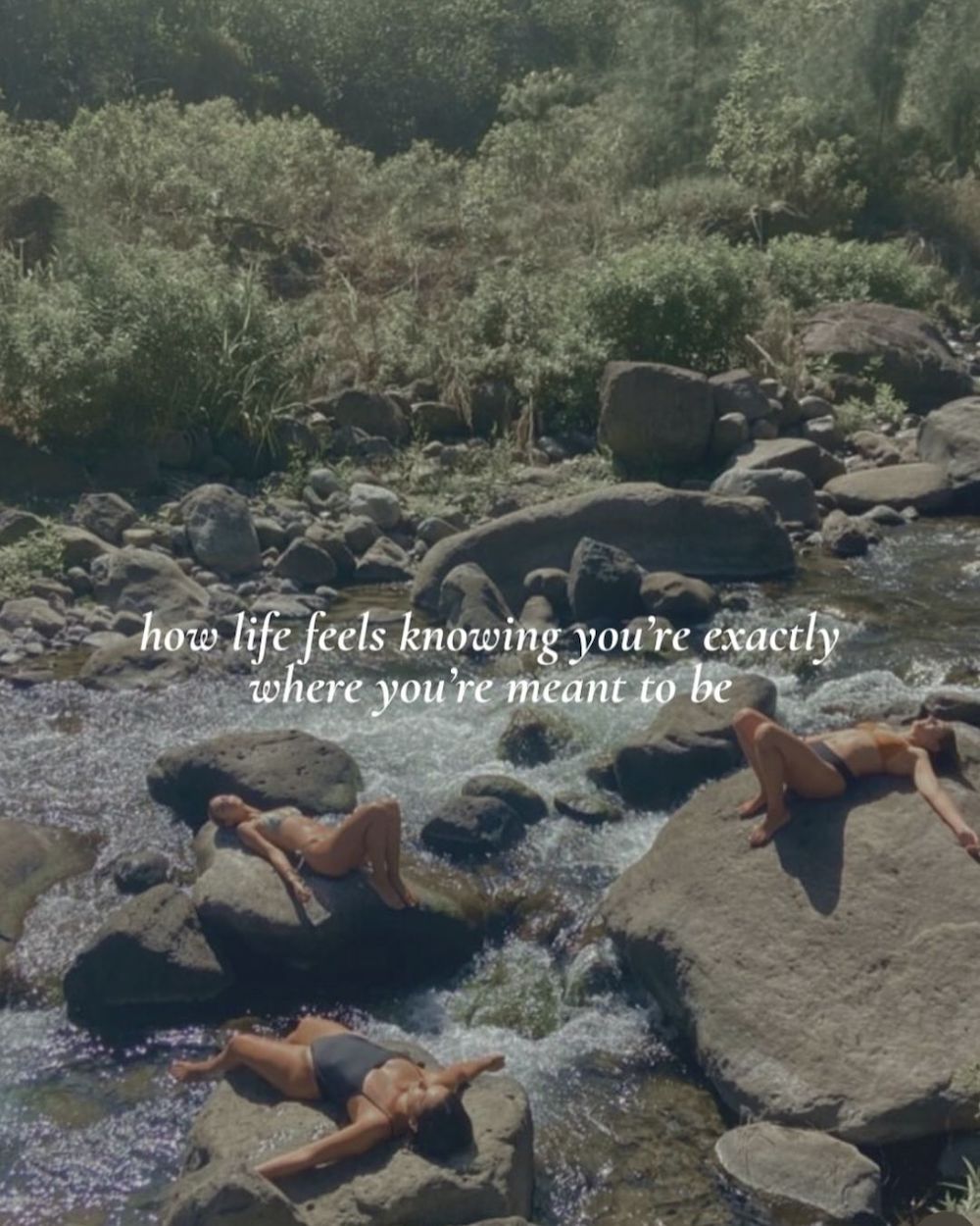 Three people sunning themselves on big boulders in the middle of a stream. Text overlaid on this image says: how life feels knowing you're exactly where you're meant to be.