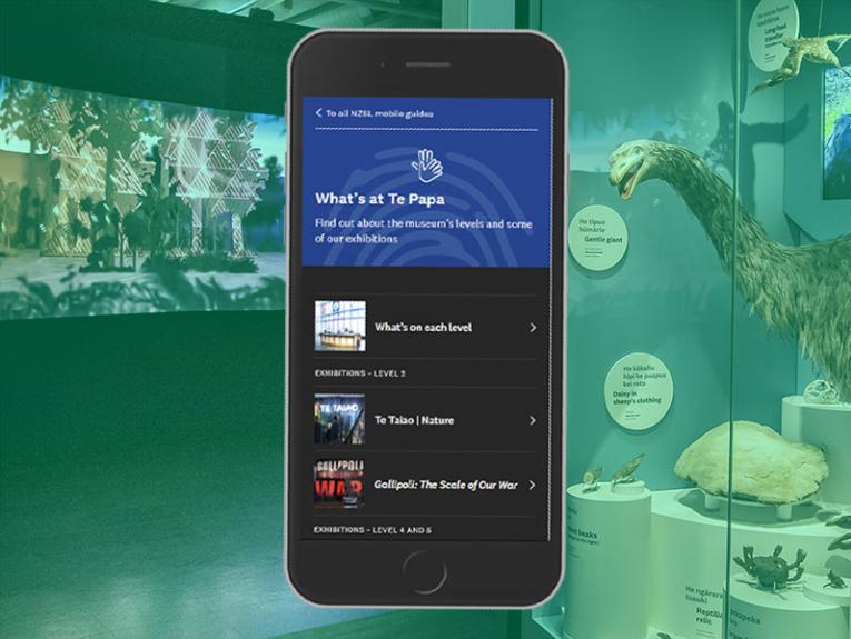 A mobile phone with a series of pages on ie with a room in a museum in the background