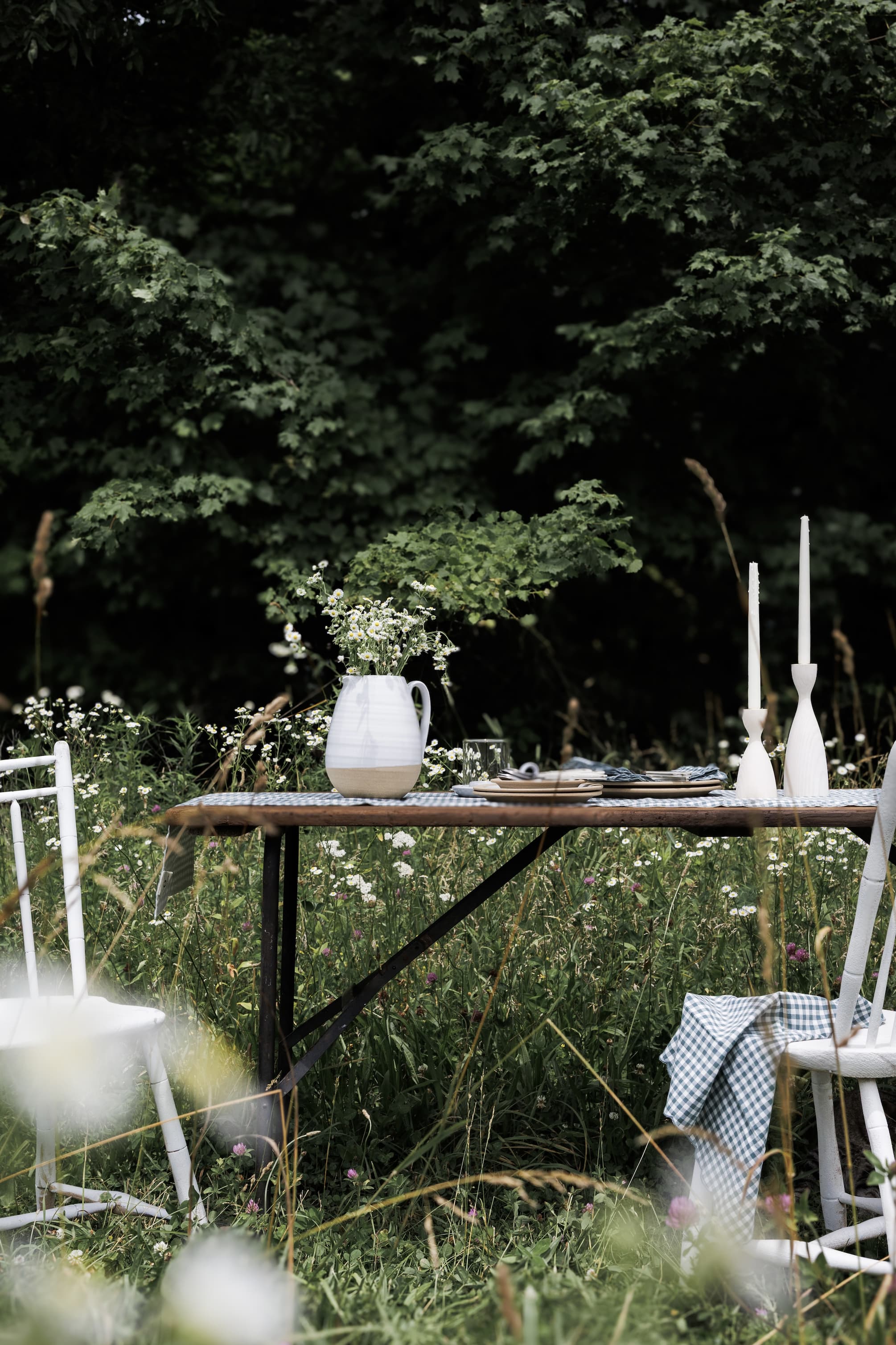 A Farmhouse Pottery table set with plates and linens