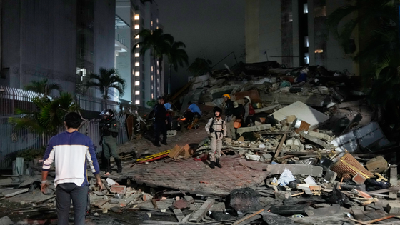 People walk amid debris after an earthquake in Caracas. 