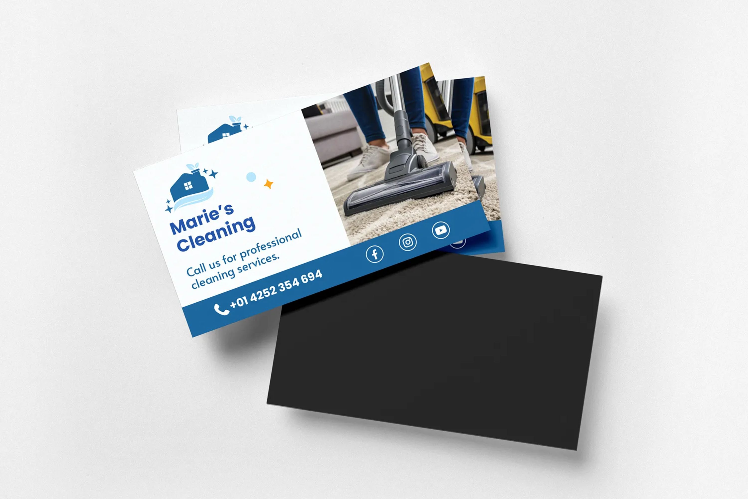 Cleaning service business cards displayed with vacuuming image and contact information