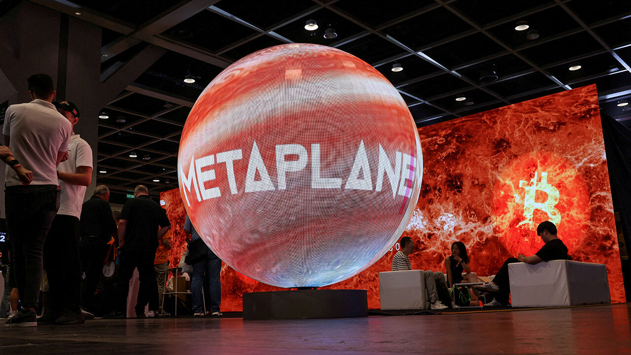Visitors walk near Metaplanet’s booth during the Bitcoin Asia conference, in Hong Kong