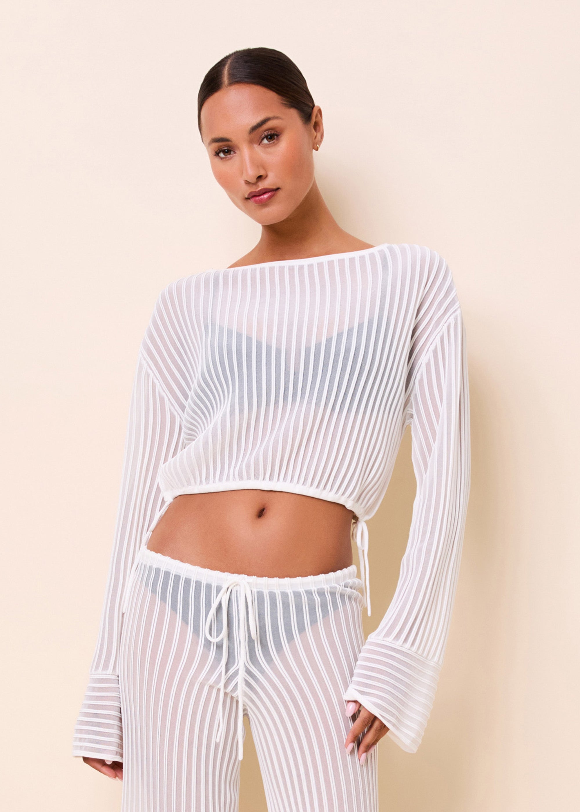woman in an open knit long sleeve bathing suit cover up top