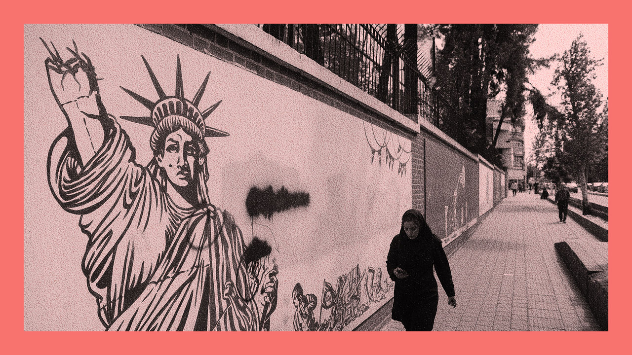 An Iranian woman walks past an anti-U.S. mural on a street in Tehran, Iran. The mural is the Statue of Liberty with half of the torch arm missing.