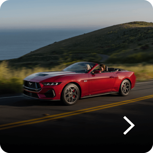 A red Ford Mustang® GT Premium Convertible being driven on a highway