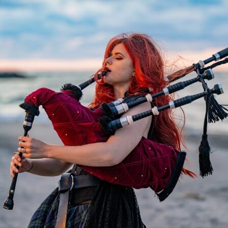 Woman playing bagpipes on a beach