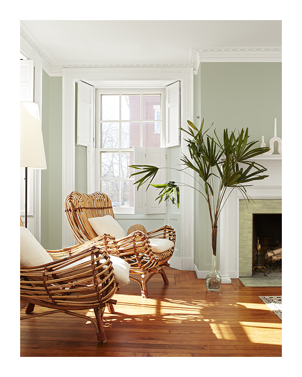 A living room with green paint and a ceiling and trim both painted white.