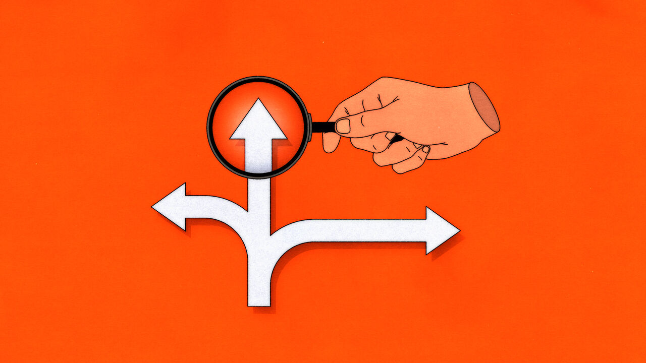A hand holding a magnifying glass over three arrows diverging from each other