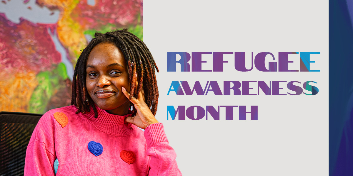 Woman in pink sweater smiling. Refugee awareness month.