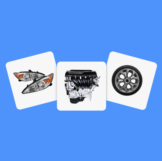 A pair of car headlights, a car engine, and a single car tire sit on white tiles against a light blue background.