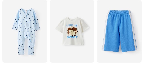 Three children's clothing items: blue dotted pajamas, cream "Life is" graphic tee, and blue shorts with white stripe