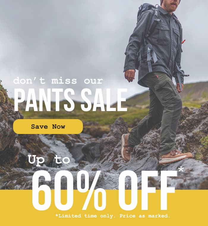 Photograph of a man hiking along a creek in Iceland on a moody day, wearing Kiwi Pro Expedition Pants.