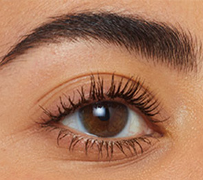 Woman wearing mascara with dramatic thick lashes