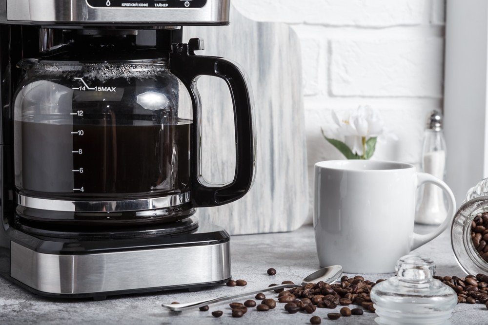 A black drip electric coffee machine brews coffee
