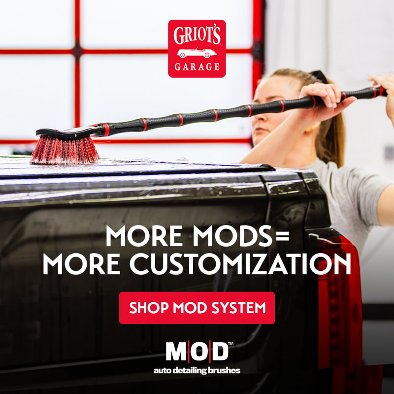 woman scrubbing the back of her truck with with MOD extensions and flat head brush