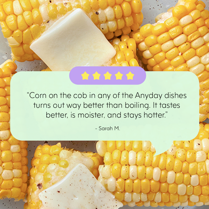 Close-up of cooked corn on the cob pieces topped with pats of butter, overlaid with a five-star rating graphic and a customer review that reads: “Corn on the cob in any of the dishes turns out way better than boiling [in the Anyday]. It tastes better, is moister, and stays hotter.” – Sarah M.
