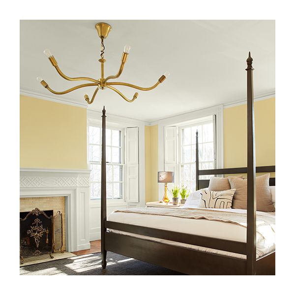 A bedroom with pale yellow-painted walls, a white ceiling, trim, and shutters.