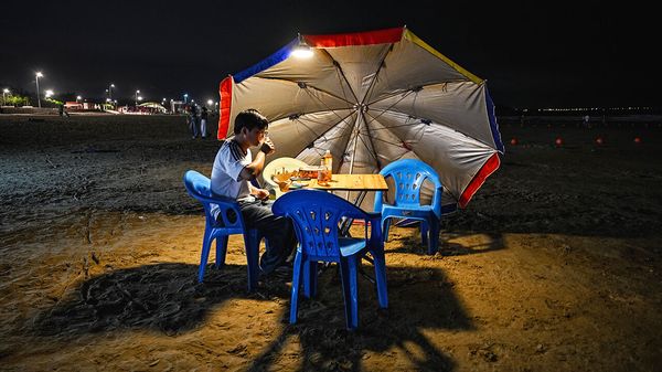 A man relishes food and drinks at a beach in Pingtan island, the closest point in China to Taiwan's main island, in Fujian province on May 19, 2024.