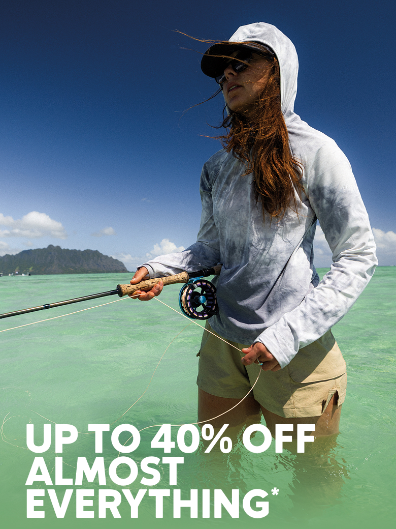 A woman standing in the water, holding a fishing rod with text: UP TO 40% OFF ALMOST EVERYTHING*