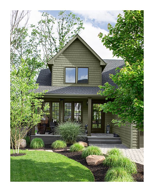 A house with green painted exterior siding and a columned front porch.