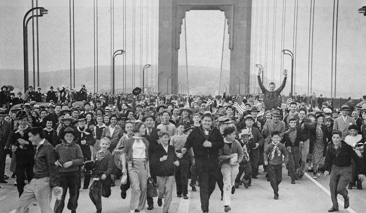 A huge crowd of people walk across the Golden Gate Bridge.