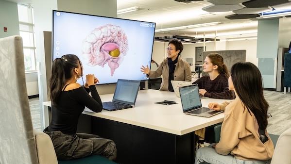 Students and instructor working together in a classroom at Carleton