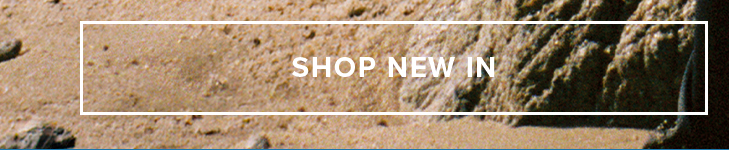 "SHOP NEW IN" text on a textured sandy beach background, inviting users to explore the new arrivals and latest collection.