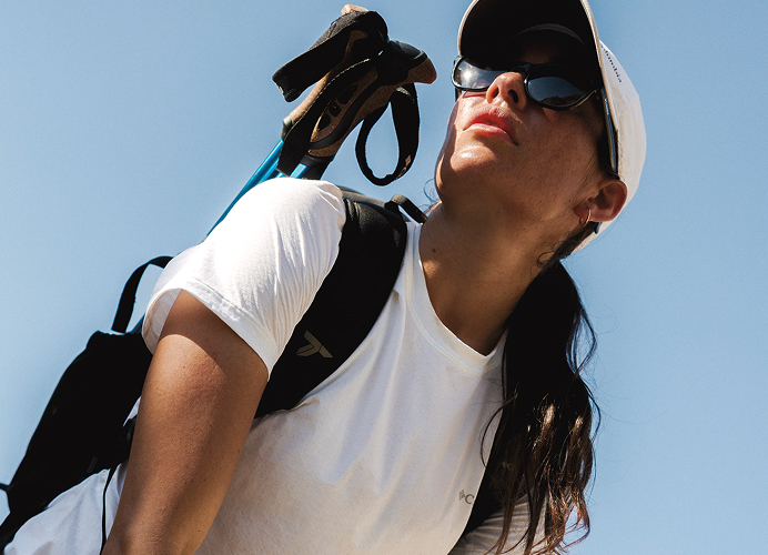 A close-up of a woman wearing Columbia gear against a blue sky.
