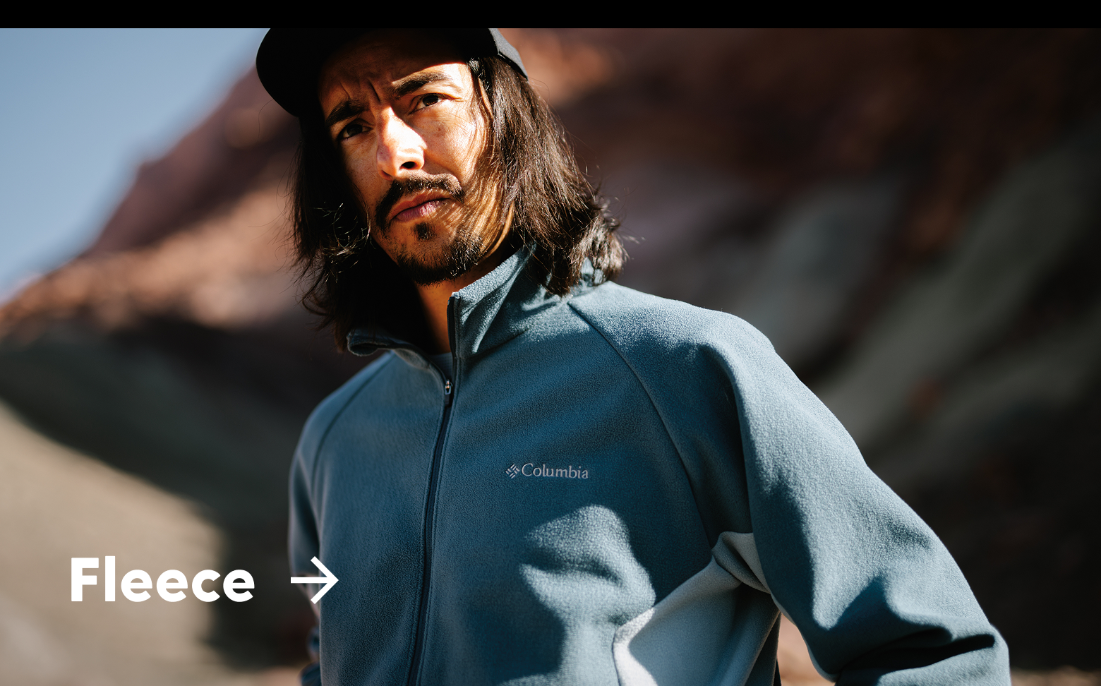 A man wearing a blue fleece jacket out in a rocky landscape with text: Fleece