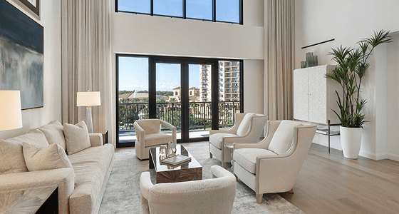 A grand interior living room with large windows overlooking landscaped grounds.