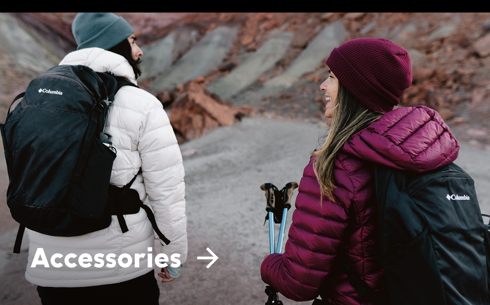 Two women wearing puffer jackets and hats in a rocky landscape with text: Accessories